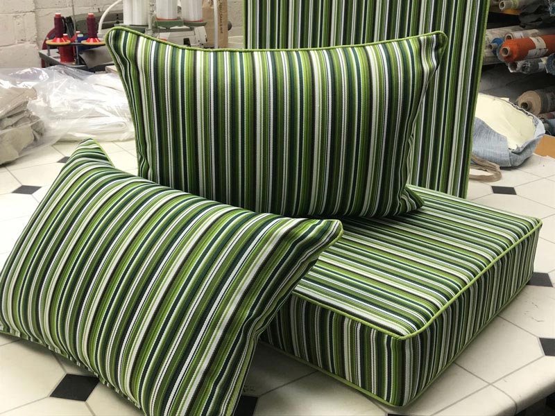 A set of new bespoke outdoor cushions covered in a contemporary stiped fabric